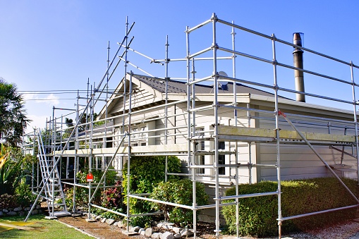 A house is surrounded by scaffolding as works take place on the rood.