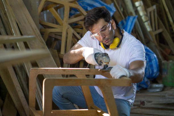 istock A man is focused as he shapes a piece of wood with his tools in a workshop setting. 2134414304
