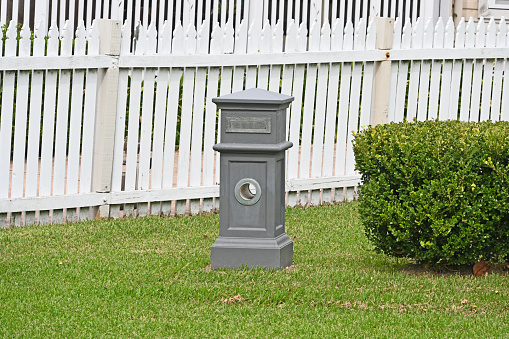 Grey concrete mailbox with a hole for newspapers