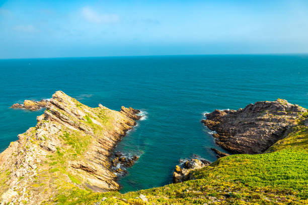 Scenic coastal landscape with vibrant green hills and blue ocean under a bright sky.Sintra-Cascais Natural Park (Parque Natural de Sintra-Cascais), close to Lisbon, Portugal