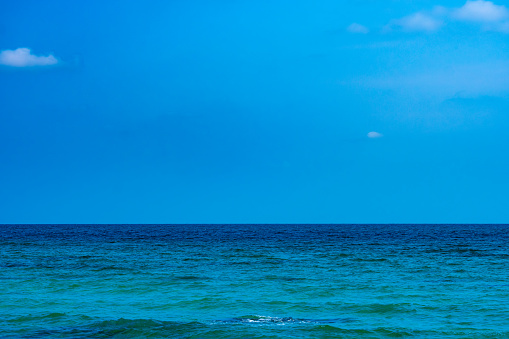 Beach sand background for summer vacation concept. Beach nature and summer seawater with sunlight light sandy beach Sparkling sea water contrast with the blue sky.