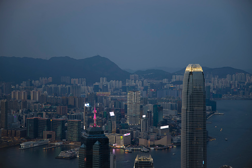 An aerial shot of a scenic twilight skyline of Kowloon's eastern cityscape with illuminations at night