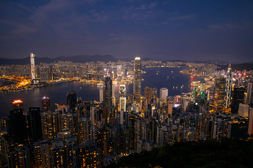 Hong Kong Downtown and Victoria Harbor. Financial district in smart city. Skyscraper and high-rise buildings. Aerial view at night.