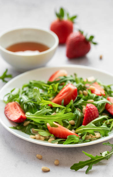 istock Fresh Strawberry Arugula Salad With Pine Nuts Served on a Bright Day 2134565014