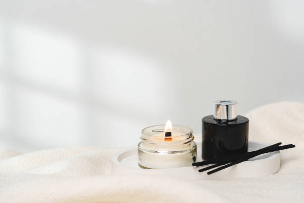 istock Elegant Aroma Diffuser With Reed Sticks And Scented Candle On White Tablecloth 2134588251