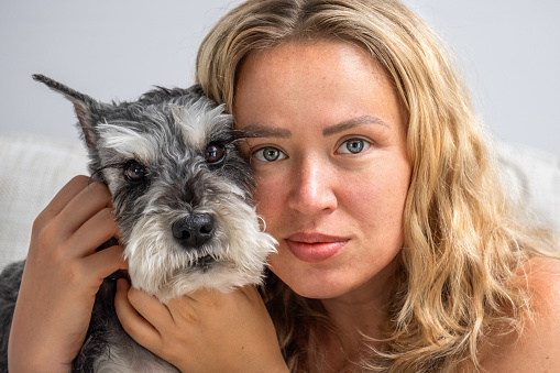 Portrait of a girl with a miniature schnauzer dog close up