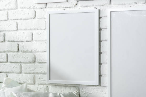 istock Varied Sized Photo Frames Displayed on a White Brick Wall 2134614530