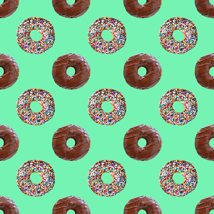 Seamless Pattern of Two Types of Delectable Chocolate Glazed Donuts on Mint Green Backdrop