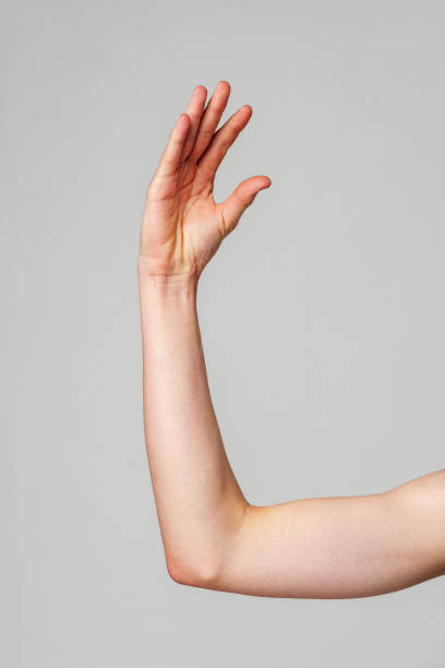 istock Close-Up of a Human Arm Extended Against a Plain Background 2134660105