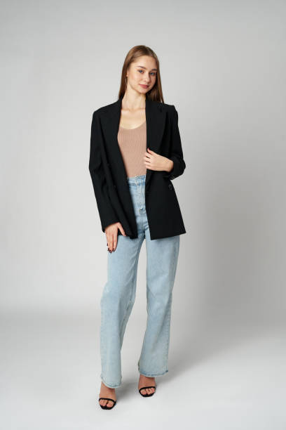 istock Young Woman Wearing Black Jacket and Jeans posing on gray background studio shot . 2134660108