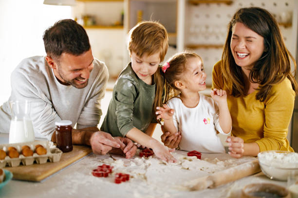 istock Happy family having fun while making cookies in the kitchen. 2134670046