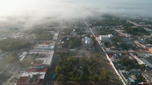 Drone shot in the foggy morning going by the famous Iglesia de San Servacio church revealing cityscape of the beautiful city of Valladolid, located in the state of Yucatan in Mexico shot in 4k.