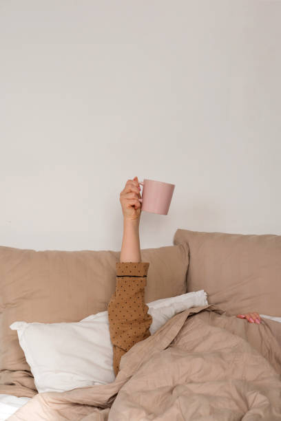 istock Arm holding coffee mug in bed 2134711611