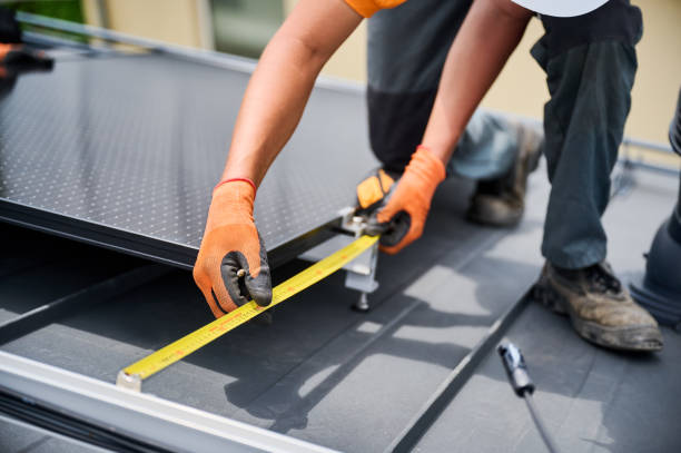Worker building photovoltaic solar panel system, using ruler to measure mounting equipment.