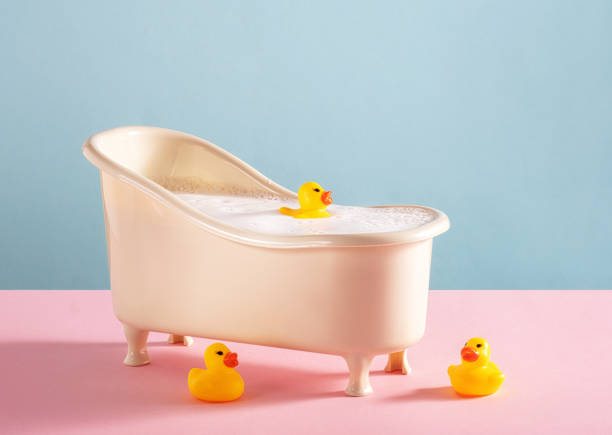 istock Bath with rubber ducks on pink and blue background. 2134726780