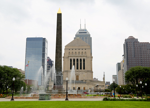 Indianapolis, IN, USA-September 02,2014:The Veterans Memorial Plaza, also called Obelisk Square, is located on the third block, south of American Legion Mall.[9] The 100-foot (30 m) black granite obelisk was built in 1923 and the square was completed in 1930.[24] Near the base of the obelisk are 4-foot (1.2 m)-by-8-foot (2.4 m) panels placed in 1929 representing law, science, religion, and education intended to represent the fundamentals of the nation