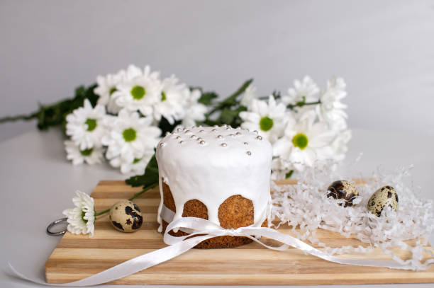 istock Easter cake in glaze stands on a board with quail eggs and white flowers 2134737075