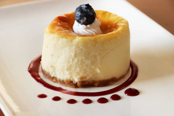 obraz božské rozkoše/ borůvkový vanilkový cheesecake/ tvarohový dort s coulis, individuální pudink podávaný s elegancí - dílek dortu fotky - stock snímky, obrázky a fotky
