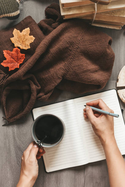 istock woman hands knitting dark brown sweater and taking notes 2134765281