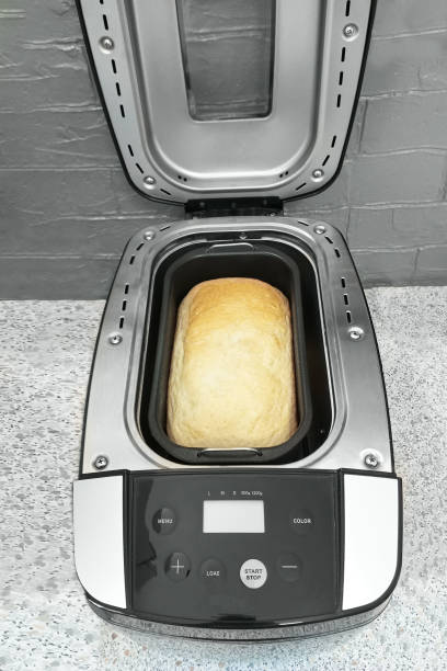 istock Freshly baked bread in an open bread machine on a table in the kitchen. 2134783879