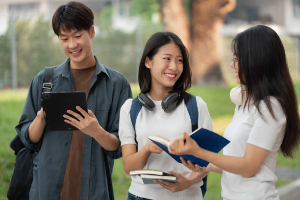 istock Asian students joining study book, smiling with laptop computer tablet at high school university, college, vacation, summer vacation. 2134807581