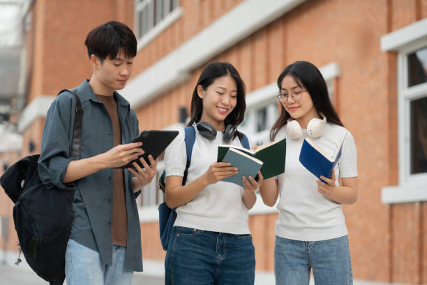 istock Asian students joining study book, smiling with laptop computer tablet at high school university, college, vacation, summer vacation. 2134807583