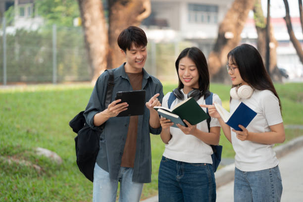 istock Asian students joining study book, smiling with laptop computer tablet at high school university, college, vacation, summer vacation. 2134807596