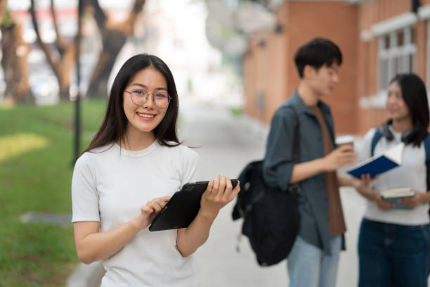 istock Asian students joining study book, smiling with laptop computer tablet at high school university, college, vacation, summer vacation. 2134807626