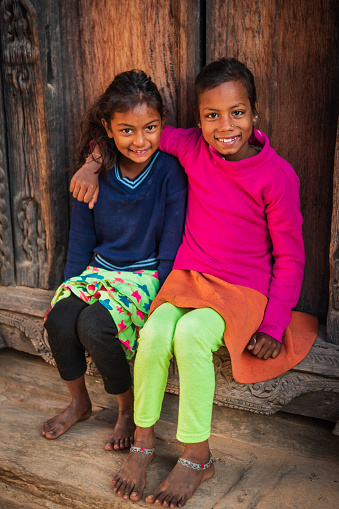 Portrait of two young Nepali sisters, they live in Bhaktapur. Bhaktapur is an ancient town in the Kathmandu Valley and is listed as a World Heritage Site by UNESCO for its rich culture, temples, and wood, metal and stone artwork.