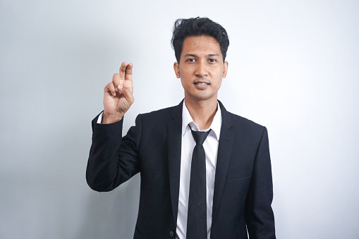 young asian man wearing suit with two fingers