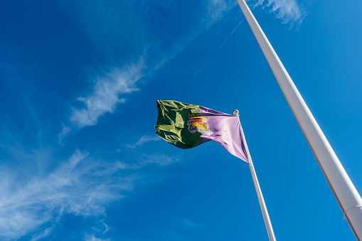 Málaga city flag on the pole, waving in the wind in Málaga in Spain.
