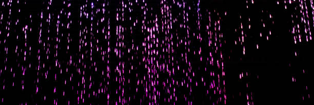 istock Drops of pink rain on a black background 2134845351