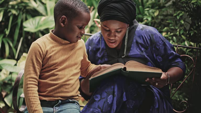 African mother and her son enjoying reading book together