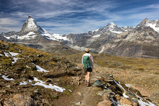En route from Hotalli to Ze Seewjinu mountain lodge, Switzerland - At an altitude of 2500 meters, a lone hiker is captivated by the trails panoramic views, including the imposing Matterhorn.