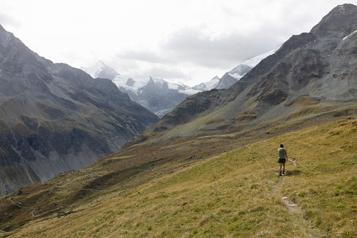 Zinal, Switzerland - A lone hiker makes their way through the expansive Alpine landscape on the trail to 'Le Cabane du Petit Mountet'.