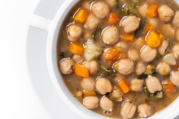 White beans soup with vegetables in white bowl isolated on white background.