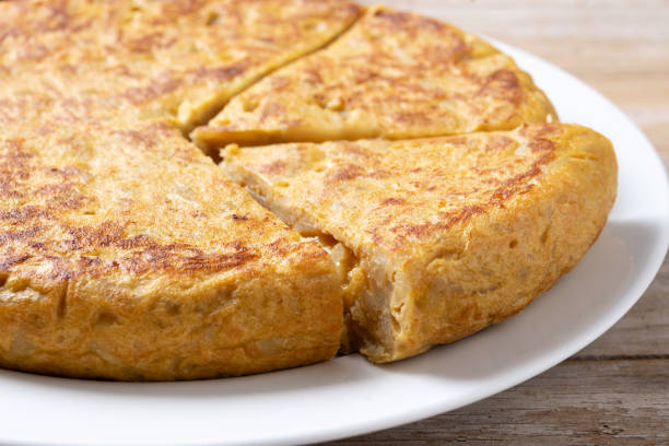 istock Traditional spanish omelette with ingredients on wooden table. 2134891965