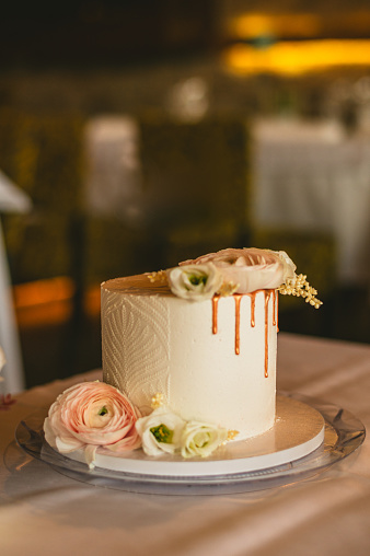 Half naked wedding cake, flowers and gold decoration