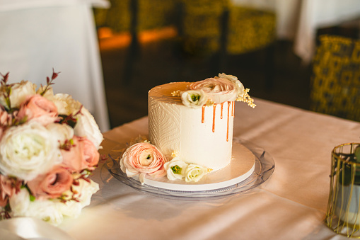 Half naked wedding cake, flowers and gold decoration