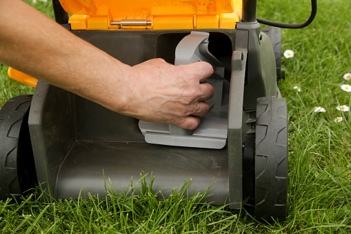 Close up image of lawn mower with inserted mulching plug, a cutting function that finely shreds the clippings and spreads it over the ground as a fertiliser.