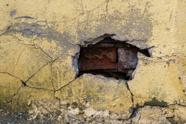istock Hole with cracks in an old brick wall 2134906294