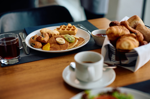 A big breakfast set with Americano and hot latte, served on a wooden table background