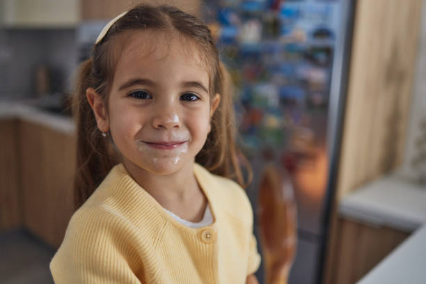 A detailed close-up photograph featuring a young child with long blonde hair and wearing a vivid yellow garment, creating a vibrant and cheerful scene. The composition highlights youthful innocence and simplicity, bringing attention to the contrasting colors and natural light.