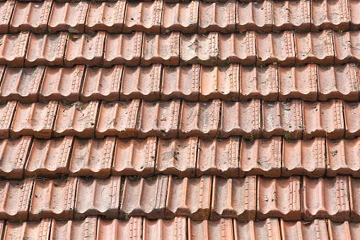 Orange colored tiles a bit weathered on roof top, full frame