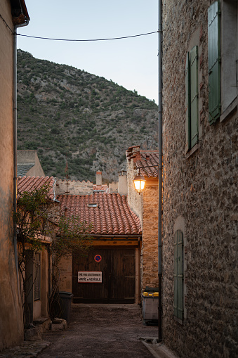 French alley of a typical village of Villefranche de Conflent at sunset. end of the alley with a garage that says: no parking exit of vehicles.