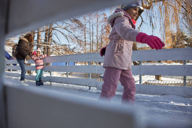 Grandmother and granddaughters enjoying ice-skating together.