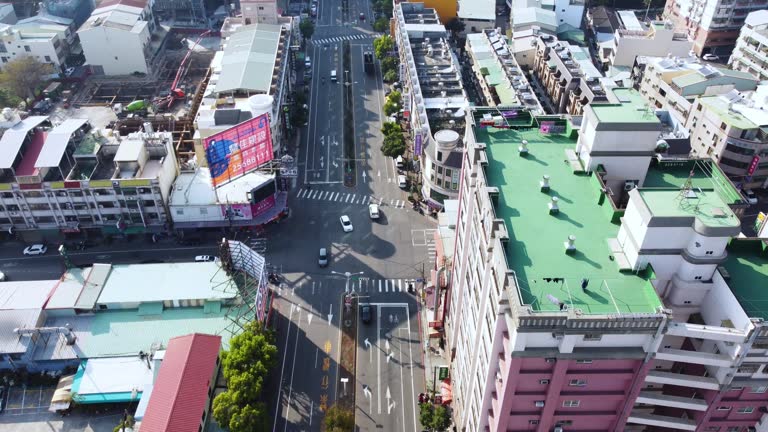 A busy urban area with cars and buildings, sunny day, aerial view