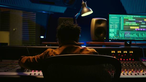 istock African american sound producer connecting coiled cable on mixing console 2135044611