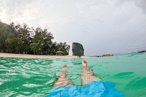 Young man's feet as he is floating in the Andaman sea in Thailand. His POV.