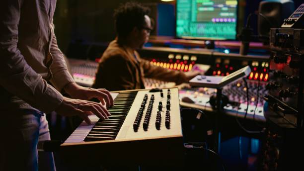istock Musician playing piano midi controller in control room at recording studio 2135052738